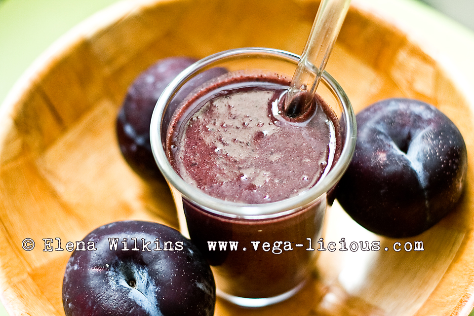 green smoothie, peaches, plumbs, glass straw and a smoothie, plums in a bowl with a smoothie